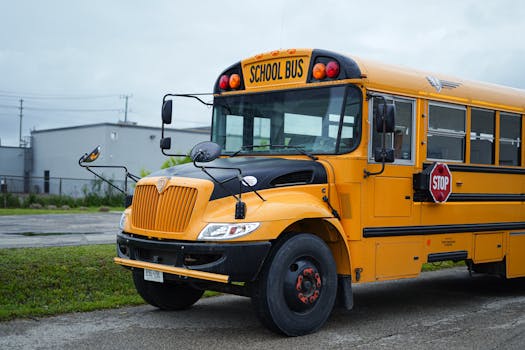 Yellow school bus parked outdoors in Kitchener, Ontario, under cloudy skies.